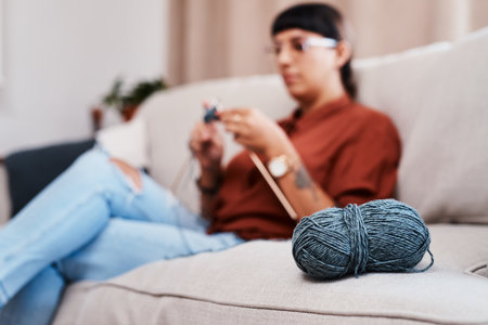 I have balls, balls of yarn. a young woman knitting while relaxing at home.の写真素材