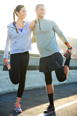 This run is going to be great. a two friends stretching together before a run through the city...