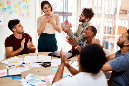 Shes been acknowledged as employee of the month. a group of young creatives applauding a colleague...