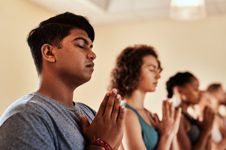Love yourself enough to take care of yourself. a group of young men and women meditating in a yoga class.の写真素材