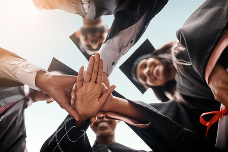 Students, graduation and group with hands stacked for college celebration outdoor. Below diversity men and women together for university achievement, education success and school graduate eventの写真素材