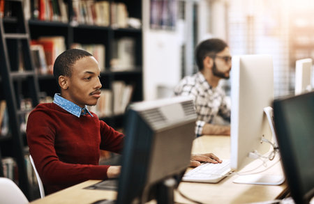 The internet helps them learn loads more. university students working on computers in the library on...