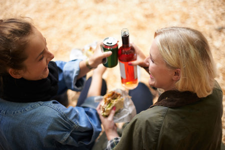 Some downtime between bands - Music Festival. Two friends enjoy a burger with their wine at a music...