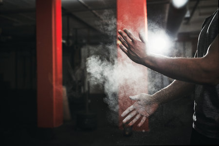 Get ready to get active. an unrecognizable man dusting his hands with talcum powder.の写真素材