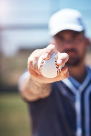 Hand holding baseball, closeup and man for sports, field and training with blurred background in sunshine. Softball player, sport and zoom of ball for training, fitness and workout for competitionの写真素材