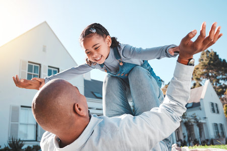 Family, happy or father lift girl in home garden for bonding, quality time or playing outdoors. Love, new house and dad with child flying in air and smile on summer vacation, weekend and holiday gameの写真素材