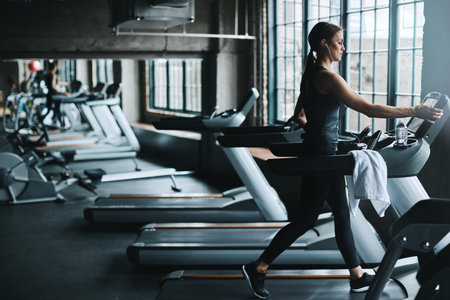 Using a machine to become one. an attractive young woman working out on a treadmill in a gym.