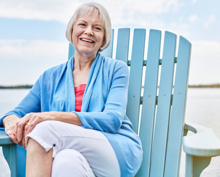 Now the relaxation really begins. Portrait of a happy senior woman relaxing on a chair outside.の写真素材