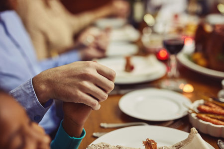 Be grateful for your abundance of blessings. Closeup shot of people holding hands in prayer before having a meal together.の写真素材