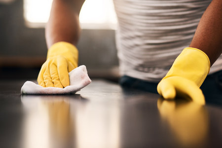 Man hands, cleaning gloves and wipe on a table with a wash cloth and housekeeping. Home, countertop and male person with disinfectant and scrub with washing in a apartment with maid and housekeeperの写真素材