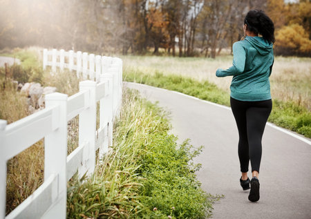 Own every workout. Rearview shot of a young woman going for a run in nature.