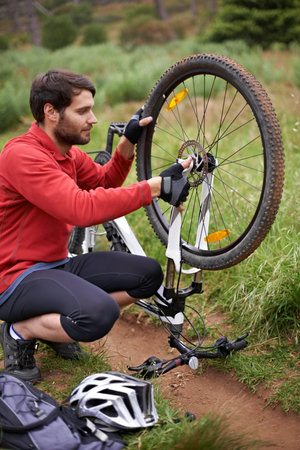Lets see where the problem lies. A young man fixing the wheel of his bicycle.