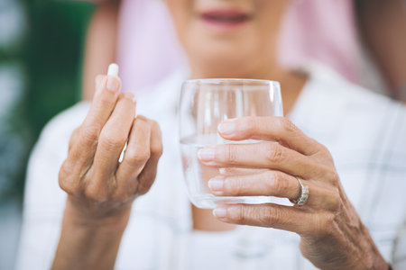 Theres a pill for every pain. an unrecognizable woman taking medication.の写真素材