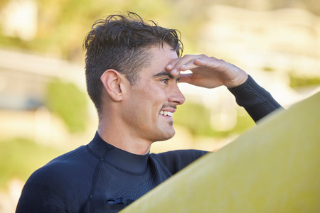 Surfer man, beach and looking with smile for waves, excited and hand by eyes for safety in morning...