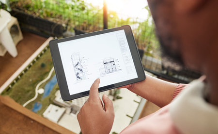 Hands, tablet and architecture design with blueprint, model and planning for property development at...
