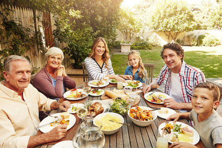 Awesome outdoor lunch with the extended family. a family eating lunch together outdoors.