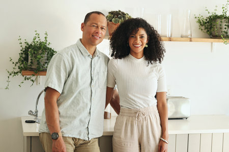 Happy, love and portrait of a couple in the kitchen of their new modern home together in Mexico. Happiness, smile and mature married man and woman bonding and embracing while standing in their house.の写真素材