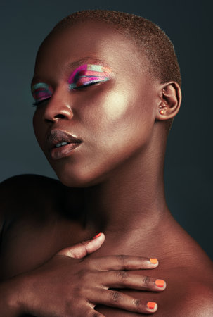 Feeling myself in some color. a beautiful woman wearing colorful eyeshadow while posing against a grey background.の写真素材