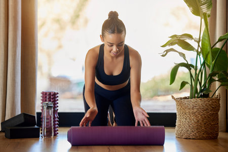 Exercise, preparation and woman with a yoga mat for fitness, cardio and training in her home. Pilates, start and girl happy for wellness, meditation and healthy lifestyle workout in her living roomの写真素材