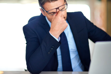 All work and no play. a businessman experiencing stress at the office.の写真素材