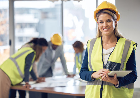 Woman, architect and tablet in leadership for meeting, construction or planning architecture at office. Portrait of happy female engineer with touchscreen for industrial team management at workplaceの写真素材