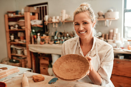 And this is the end result. a female artisan working in her pottery workshop.の写真素材