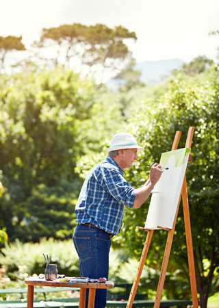 Find your passion. a senior man painting in the park.の写真素材