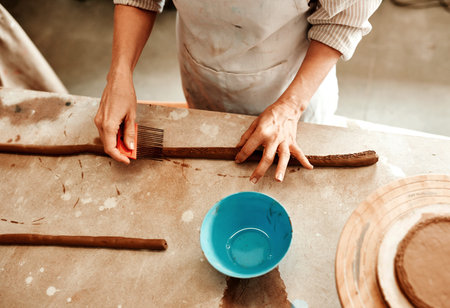 Just roll with it. an unrecognizable artisan working in a pottery workshop.