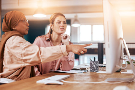 Teamwork, computer and business women planning, training and coworking or collaboration for online, digital company. Diversity people, muslim manager or leader speaking or show ideas on desktop pcの写真素材