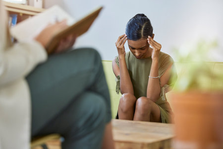 Therapy writing, psychologist and woman headache with stress, and burnout in office. Support, therapist consultation and mental health check with psychology work of a patient on a consulting sofaの写真素材