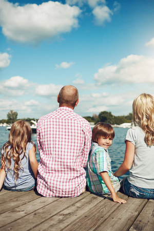 Making memories for life. a family on a pier while out by the lake.の写真素材