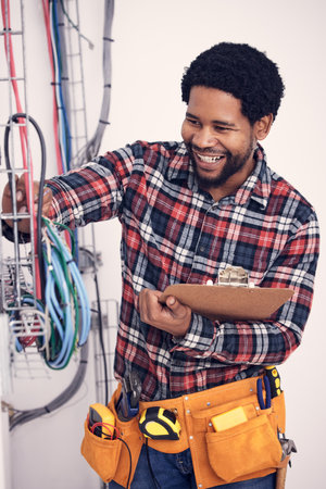 Electrician, electric wires or happy man for maintenance check of cable system, wiring or installation service. Quality control inspection, African male or technician repair electricity power supplyの写真素材