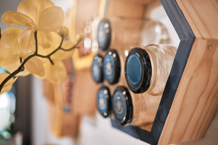 Jar, honey and product in a wellness store or small business with natural, organic and raw honeycomb. Retail, food and shelves of a sustainable bee farm syrup on sale in a health and nutrition shop.の写真素材
