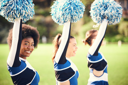 Black woman cheerleader, field and smile in portrait for teamwork or sport motivation in sunshine. Girl, group and fitness for diversity, support or solidarity for balance, muscle or trainingの写真素材