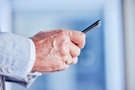 Hands, phone and email with a business man in his office, closeup for communication or networking. Mobile, contact and internet with a male employee typing a text message or making a callの写真素材