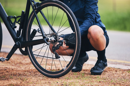Person, bike and wheel repair outdoor for training, triathlon sports and transportation problem. Closeup of athlete, bicycle and check tire chain for travel safety, cycling maintenance and fixing hubの写真素材