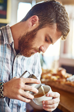 Making it just how you like it. a barista making coffee.の写真素材