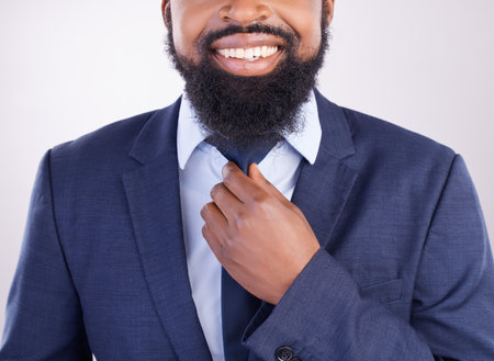 Corporate, black man and fixing tie in studio for business fashion, manager and professional clothes in leadership. Closeup, happy executive and male model in suit for CEO, confidence and happinessの写真素材