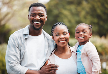 Happy, portrait and black family outdoor, hug and bonding in a park, loving together and weekend break. Face, mother or father with female kid, daughter or embrace with child development and backyardの写真素材