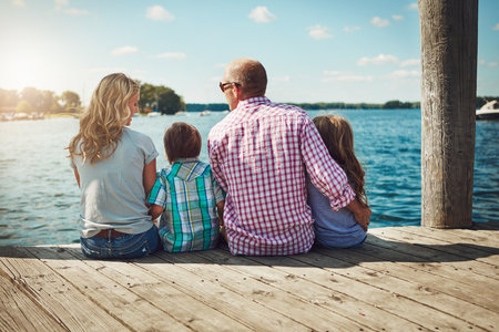 When we have each other, we have everything. a family on a pier while out by the lake.の写真素材