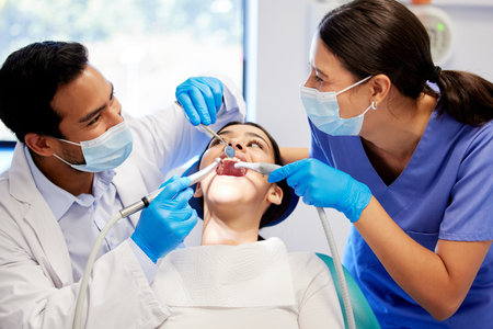 Gentle care in the dentists chair. a young woman having a dental procedure performed on her.の写真素材