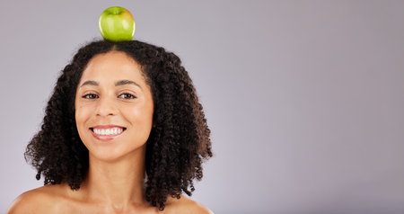 Apple, green fruit and portrait of a black woman holding wellness food for detox and weight loss. Skincare, beauty and young model in a isolated studio for nutrition and vitamin diet with mockupの写真素材