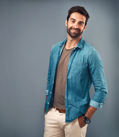 Hes what they call Mr Perfect. Studio portrait of a handsome young man posing against a grey...