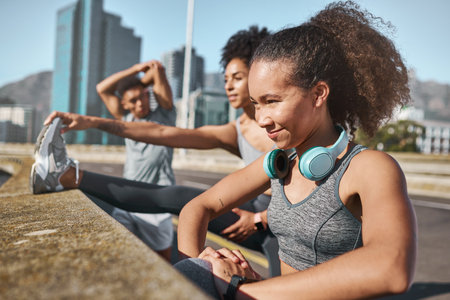 Fitness, running and stretching with a woman group getting ready for a workout or training outdoor together. Health, wellness and exercise with female athlete friends warming up for a cardio runの写真素材