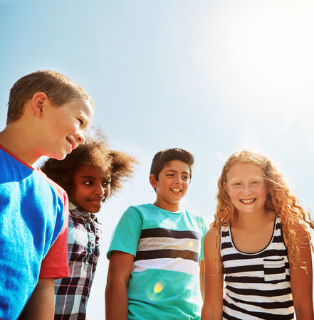 Summer days bring out the bests smiles. Portrait of a group of diverse and happy kids hanging out together on a bright day outside.の写真素材
