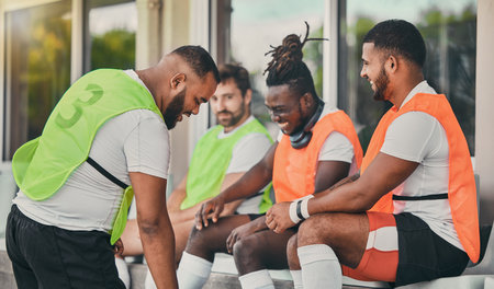 Rugby men, teamwork and fitness on bench, laughing or comic chat for diversity, solidarity and happy. Group team building, university or professional sport at stadium for relax, friends or funny timeの写真素材