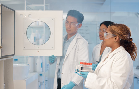 Are you ready for this. a group of scientists inserting a tray of samples into a storage unit.の写真素材