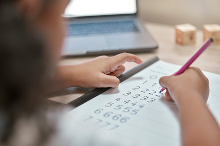 Girl hands, math and writing on paper, counting and homework with number, elearning and laptop in...