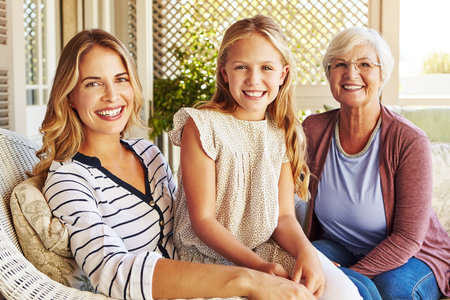 Proud to be a part of this family. Cropped portrait of a young girl sitting outside with her mother and grandmother.の写真素材