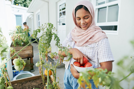 Time to turn you into a salad. an attractive young woman standing outside and gardening during the day.の写真素材